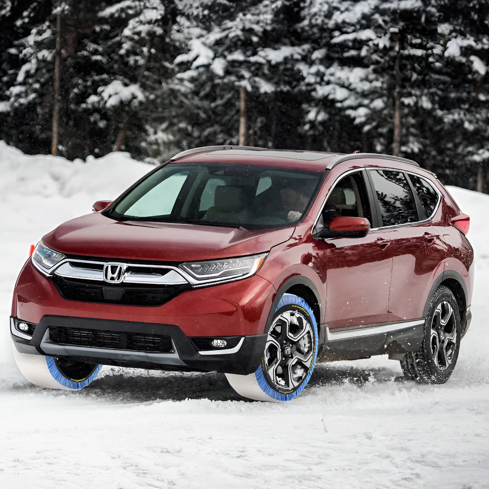 Honda CR-V rojo equipado con fundas de nieve Goodyear de color azul, conduciendo en un camino nevado.