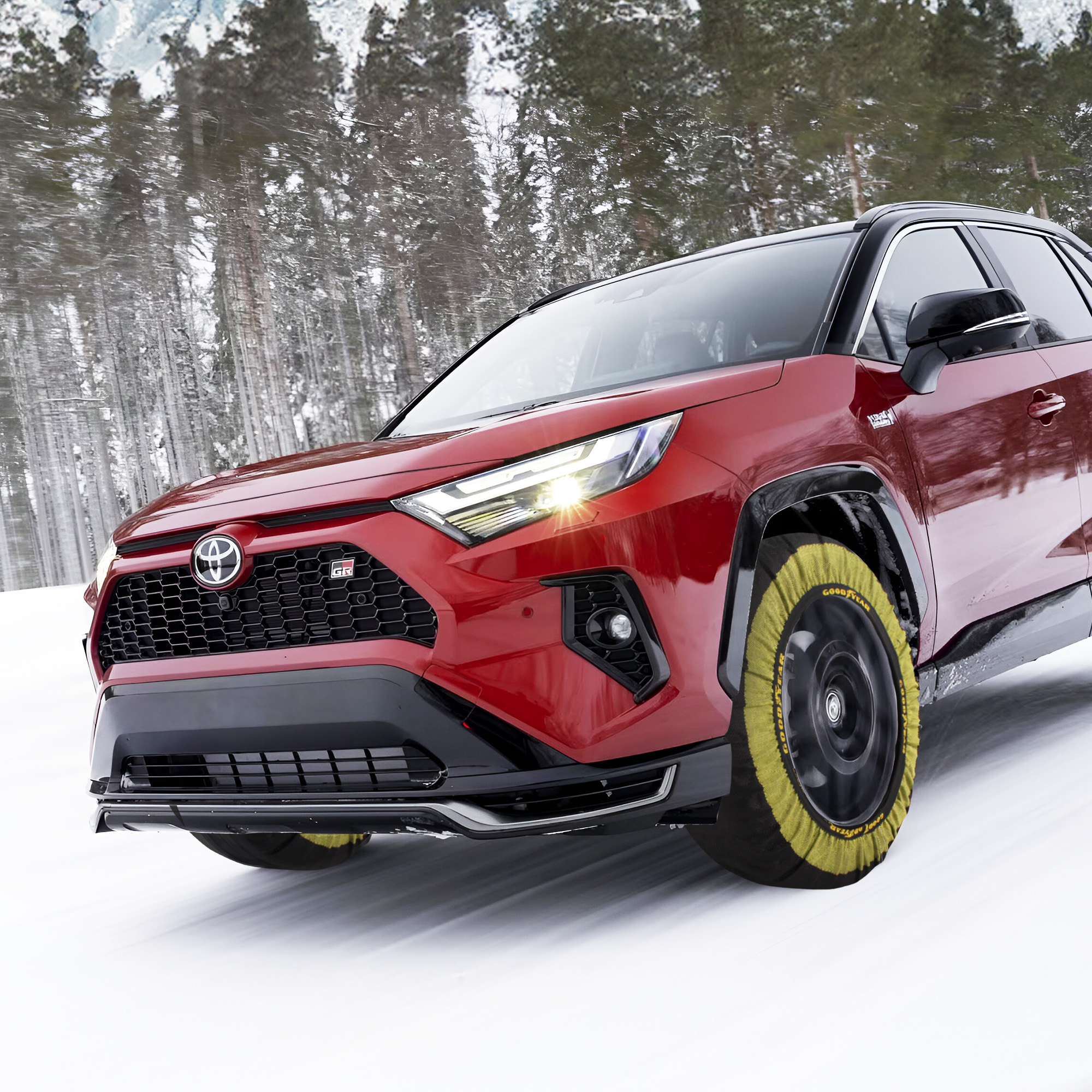 Toyota RAV4 rojo equipado con fundas de nieve en las ruedas, conduciendo sobre nieve.