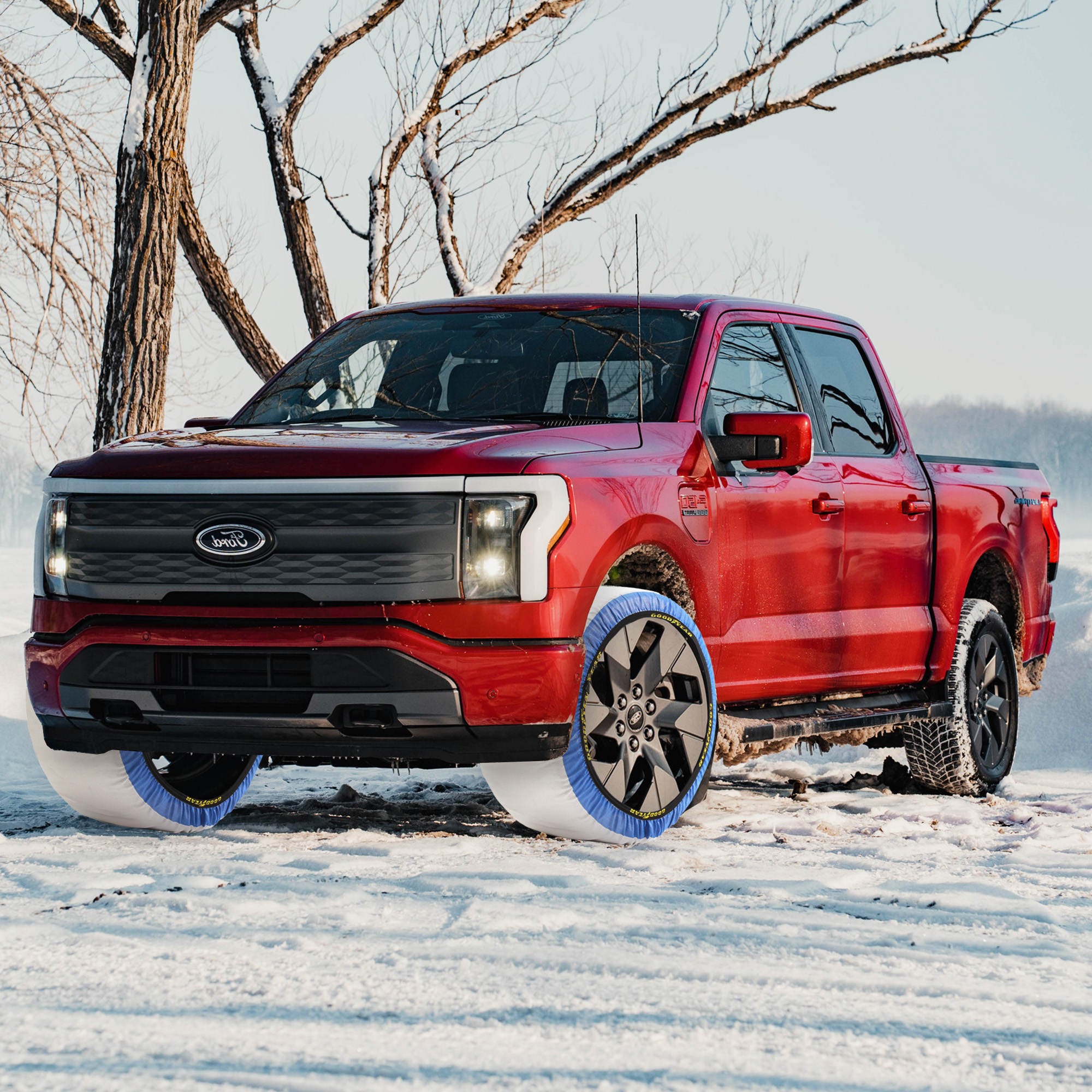 Camioneta Ford roja equipada con cubiertas de nieve en sus ruedas en un entorno nevado.