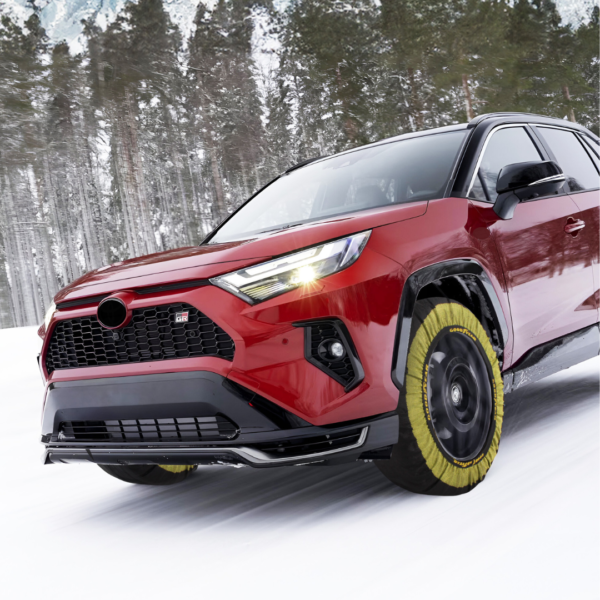 SUV rojo circulando por un camino nevado con fundas textiles para neumáticos de color amarillo.